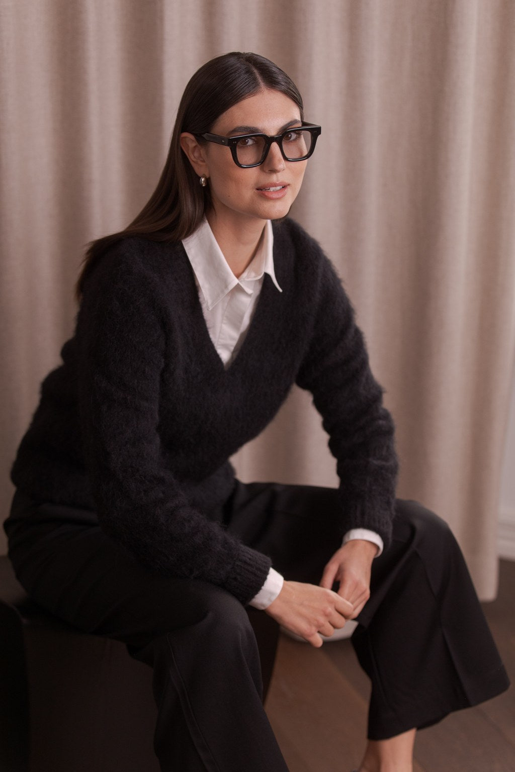 nainen, jonka päällä Original Storyn musta alpakkasekoiteneule v-kaula-aukolla