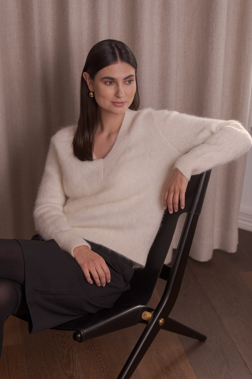 nainen, jonka päällä kermanvalkoinen alpakkasekoiteneule v-kaula-aukolla