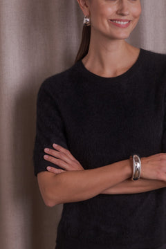 100 % kashmirneule, jossa lyhyet hihat ja harjattu pinta, sävyssä black.